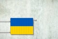 Heating battery, in the colors of the Ukraine flag on a concrete wall. Copy space. Raising heating prices. Heat saving