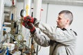 Heating engineer or plumber in boiler room installing or adjusting manometer