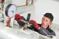 Heating engineer or plumber in boiler room installing or adjusting manometer