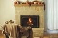 Heating house in winter with wood burning stove. Burning fireplace in rustic living room with cozy chair, rug and firewood stack. Royalty Free Stock Photo