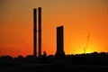 Heating plants, crane and sunset with birds