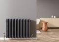 Heating radiator on gray wall in modern room. Home interior. Central heating system. Heating is getting more expensive