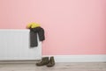 Heating radiator with knitted cap, scarf and shoes Royalty Free Stock Photo