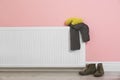 Heating radiator with knitted cap, scarf and shoes Royalty Free Stock Photo