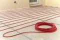 Heating red electrical cable wire roll on cement floor copy space background. Renovation and construction, comfortable warm home Royalty Free Stock Photo