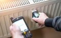 Heating system engineer ist adjusting the digital w-lan network thermometer reader on a new thermal radiator