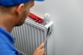 Heating system installation and maintenance service. plumber installing radiator