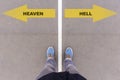 Heaven or Hell text on asphalt ground, feet and shoes on floor Royalty Free Stock Photo