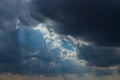 Heavenly Sun Rays Through Dark Clouds Against The Blue Sky. Royalty Free Stock Photo