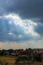 Heavenly Sun Rays Through Dark Clouds Against The Blue Sky. Royalty Free Stock Photo