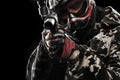 Heavily armed masked paintball soldier isolated on black background. Ad concept.