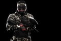 Heavily armed masked paintball soldier isolated on black background. Ad concept.