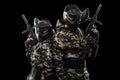 Heavily armed masked paintball soldier isolated on black background. Ad concept.