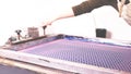 heavily blurred background panel with female arm clamping a screen printing frame in a fixture for silkscreen printing