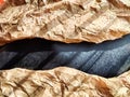 Heavily crumpled textured kraft paper with a black smooth insert in sunlight and with shadows. Abstract background Royalty Free Stock Photo