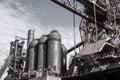 Heavily desaturated view of an industrial steel mill facility with rows of blast furnaces and related structures