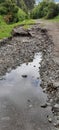 Heavily eroded road bed with stagnant water ponding, Cotacachi, Ecuador, andes, South America Royalty Free Stock Photo