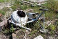 Heavily used broken and partially rusted electric concrete mixer discarded on construction site