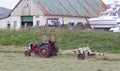 Heavily used red old tractor working on the field Royalty Free Stock Photo