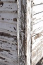 Heavily weathered wood with flaked white paint in closeup