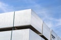 Heavy aluminum bars stacked on top of each other in an aluminum smelting plant, against the blue sky.