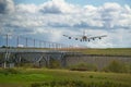 Heavy cargo airplane landing on runway with lush green and blue sky Royalty Free Stock Photo