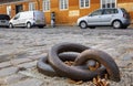 Heavy cast iron ring or eyelet anchored into cobblestone pavement