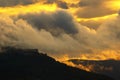 Heavy clouds in dusk sunset with mountains in silhouette Royalty Free Stock Photo