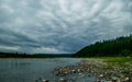 Heavy clouds over mountain river Kozhim and coniferous forest