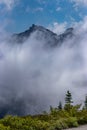 heavy clouds on summer day in rugged wilderness with mountain and trees