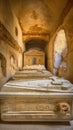 Heavy coffins lie on sand floor in an very small old dusty cemetery crypt in a cave