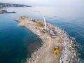 Heavy construction equipment is building a breakwater. Pouring concrete on a pier under construction in the sea. Royalty Free Stock Photo