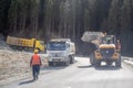 Heavy construction machinery with workers works in the Almaty mountains. Excavator, dump trucks and workers