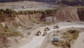 Heavy Dump Trucks At The Coal Mining Area. Aerial view of the quarry mining trucks, heavy industry and machinery concept Royalty Free Stock Photo