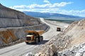 Heavy duty dump trucks on mining site with mountain view in bright daylight Royalty Free Stock Photo