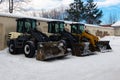 Heavy duty earth movers parked next to each other used to move snow after blizzard. Industrial excavators removing snow of the