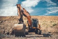 Heavy duty excavator on highway construction site, bucket details, dirt and gravel all around Royalty Free Stock Photo