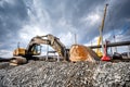 Heavy duty industrial excavator loading gravel on construction site. Details of building site Royalty Free Stock Photo