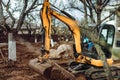 Heavy duty industrial excavator moving earth in the garden during landscaping works Royalty Free Stock Photo