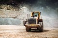 Heavy duty industrial wheel loader loading rock and  ore at crushing and sorting plant. Quarry details Royalty Free Stock Photo