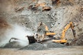 Heavy duty machinery working on quarry. Open pit ore mine details with excavator and bulldozer and hydraulic crusher Royalty Free Stock Photo