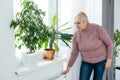 Heavy duty radiator - central heating, an elderly woman checks the heating Royalty Free Stock Photo