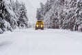Heavy duty snow bus vehicle plows over snow of Highway 20 in Yellowstone in winter