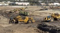 Heavy earthmoving equipment including scapers and motor graders involved in grading operations Royalty Free Stock Photo