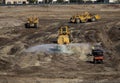 Heavy earthmoving equipment including scapers and motor graders involved in grading operations Royalty Free Stock Photo