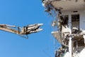 Heavy equipment hydraulic shears arrow dismantle the building, demolition destruction