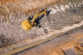 Heavy excavator ripping big stones from mountain ground with help of duty single shank excavator ripper, top down aerial photo
