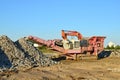 Heavy excavator working in quarry on a background of sunset and blue sky.