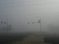 Heavy fog and traffic lights with patched roads