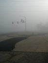 Heavy fog and traffic lights with patched roads, vertical image